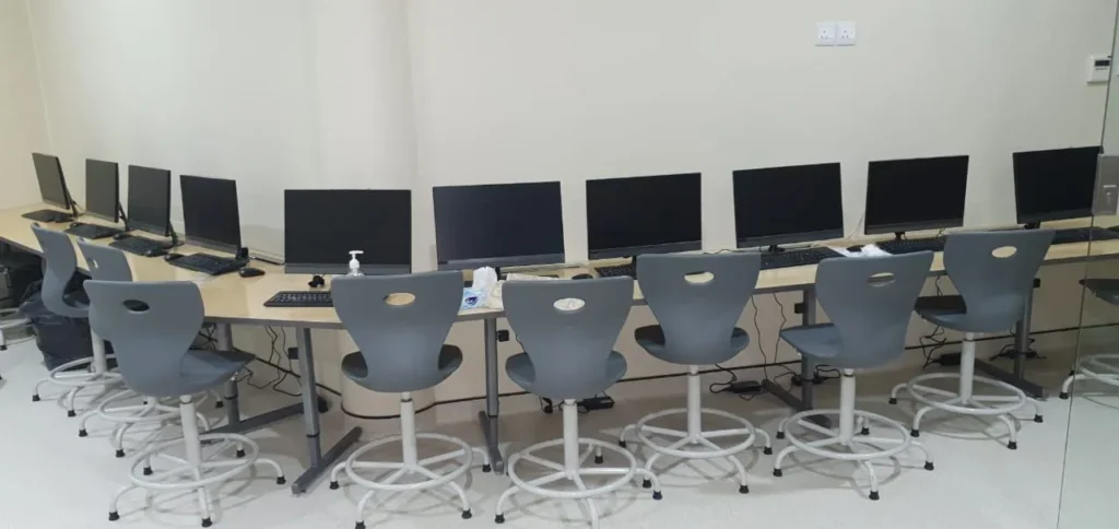 تجهيز معمل حاسوب مدرسي حديث بعدد من أجهزة الكمبيوتر والكراسي المريحة ضمن خدمات تجهيز المدارس والمعامل التعليمية