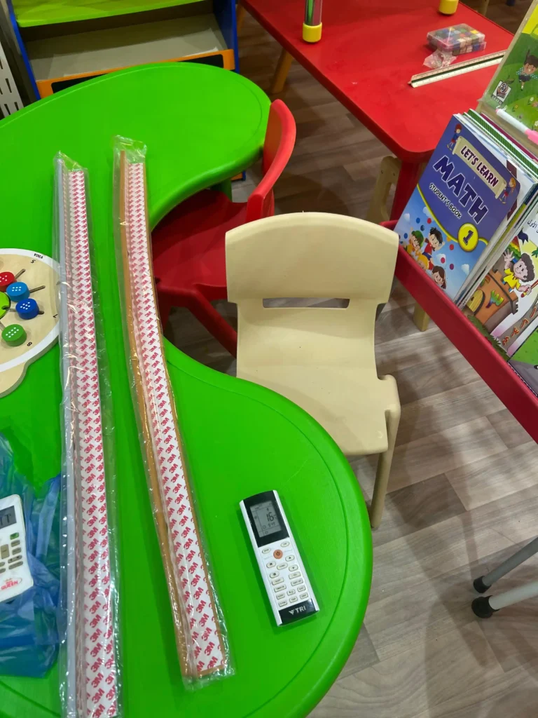 طاولة خضراء وكرسي واداة تحكم خاصة بتجهيز الحضانات