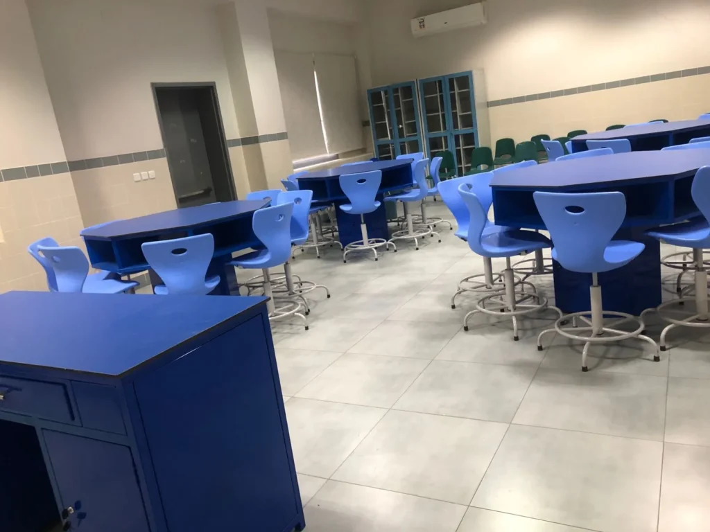 كراسي وطاولات المدارس بتصميم حديث داخل معمل دراسي مجهز لبيئة تعليمية تفاعلية